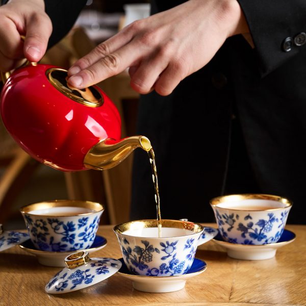 pouring tea from a red kettle